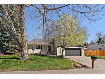 Charming single-story home with a well-maintained lawn, mature trees, and inviting curb appeal at 12155 W 68Th Pl, Arvada, CO 80004