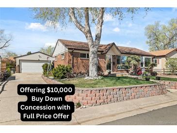 Charming brick home featuring a well-maintained front yard, mature tree and detached garage at 10769 Murray Dr, Northglenn, CO 80233