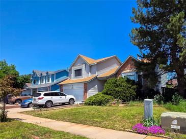 Charming home with well-maintained lawn and mature trees on a sunny day at 20391 E 42Nd Ave, Denver, CO 80249