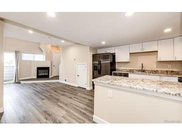 Open-concept kitchen with white cabinetry, stainless steel appliances, and granite countertops at 17004 E Tennessee Dr # 212, Aurora, CO 80017