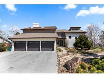 Charming home showcasing a three-car garage, tile roof and well-maintained landscaping at 12017 W 54Th Dr, Arvada, CO 80002