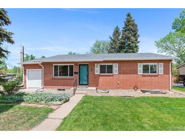 Inviting brick home with a green lawn and well-maintained landscaping, complete with an attached garage at 6025 Johnson Way, Arvada, CO 80004