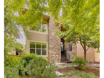 Charming two-story home with a stone facade and a beautifully landscaped front yard at 2940 Ulster St, Denver, CO 80238