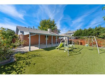 Large backyard features a playset, an outdoor patio, and artificial grass at 2692 S Pennsylvania St, Denver, CO 80210