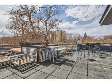 Enjoy outdoor living with this rooftop deck, featuring a bar, lounge seating, and city views at 500 E 11Th Ave # 305, Denver, CO 80203