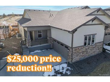 Charming single-Gathering home featuring stone accents, a covered porch, and an attached two-car garage at 17412 W 93Rd Pl, Arvada, CO 80007