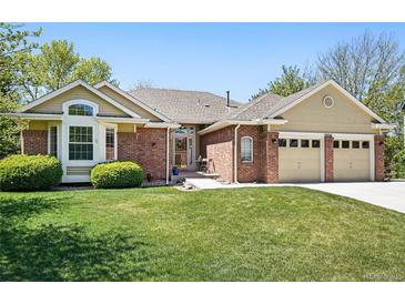 Charming home with brick accents, well-kept lawn, and attached two-car garage at 7276 Brighton Ct, Castle Pines, CO 80108