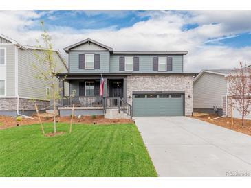 Charming two-story home with a well-manicured lawn and a two-car garage at 23998 E Atlantic Pl, Aurora, CO 80018