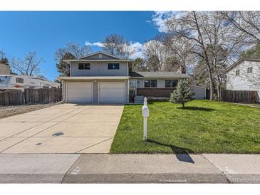 Charming two-story home with a well-manicured lawn, mature trees, and an attached two-car garage at 6458 W Clifton Pl, Littleton, CO 80128
