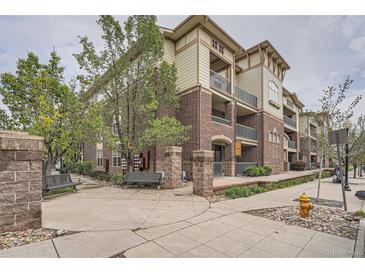 Three-story brick building with balconies and mature trees, landscaping, benches and sidewalks at 3872 S Dallas St # 7-304, Aurora, CO 80014