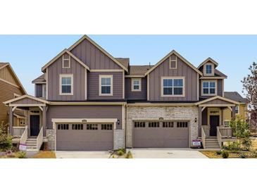 Charming townhome featuring modern architecture, two-car garage, and welcoming front porch at 6740 Juniper Dr, Thornton, CO 80602