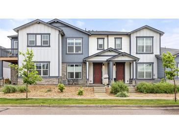 Townhome featuring a covered porch, landscaped front yard and neutral-toned exterior at 193 Ambrose St, Erie, CO 80516