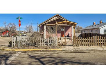 Cozy single-story home with a fenced yard, front porch, and classic architectural details at 101 2Nd St, Fort Lupton, CO 80621