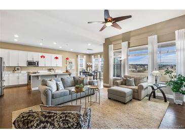 Bright, open-concept living room flows into modern kitchen and dining area with lots of natural light at 7408 Xenophon St, Arvada, CO 80005