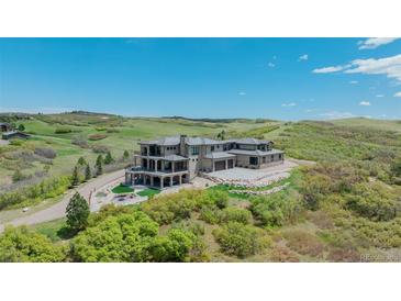Stunning luxury home on hillside with outdoor living space and fire pit at 3520 Castle Butte Dr, Castle Rock, CO 80109