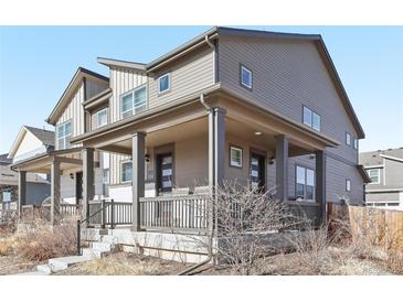 Two-story home with gray siding, front porch, and landscaping at 21795 E 8Th Ave, Aurora, CO 80018