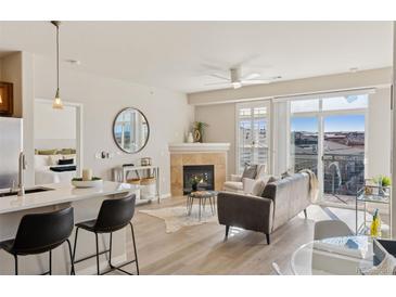 Bright living room featuring a fireplace, balcony access, and views of the surrounding city at 10176 Park Meadows Dr # 2408, Lone Tree, CO 80124