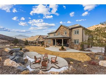 Stunning backyard featuring a stone patio, firepit, and breathtaking mountain views for outdoor enjoyment at 4937 Hogback Ridge Rd, Morrison, CO 80465