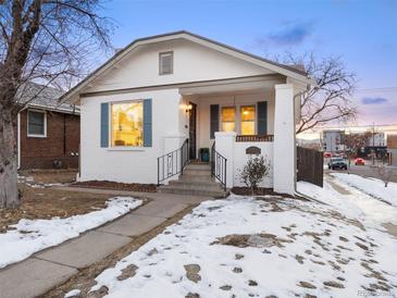 Charming bungalow with white brick exterior, snowy front yard, and inviting front porch at 1901 S Lincoln St, Denver, CO 80210