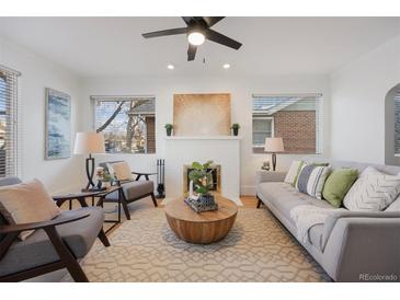 Bright living room with a gray sofa, fireplace and area rug at 1901 S Lincoln St, Denver, CO 80210