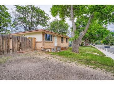 Cozy, one-story home with brick exterior, small front porch and well-maintained lawn at 5274 Alkire St, Arvada, CO 80002