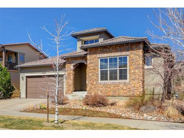 Charming stone-accented home featuring a tile roof and well-maintained landscaping at 15265 W Baker Ave, Lakewood, CO 80228