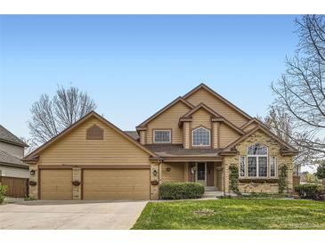 Inviting two-story home with a well-manicured lawn and an attached two-car garage at 1604 Brookside Dr, Highlands Ranch, CO 80126