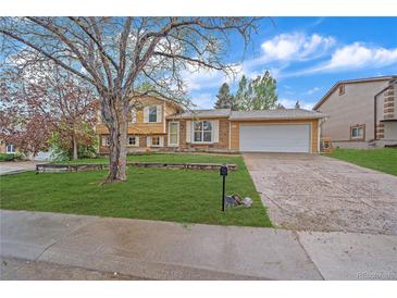 Charming single-Gathering home with a well-maintained front yard, mature tree, and driveway leading to a two-car garage at 2166 S Joplin Way, Aurora, CO 80013