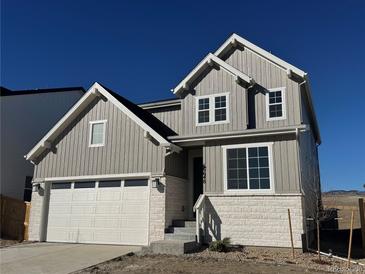 Charming two-story home featuring a two-car garage and a mix of lap siding and brick veneer at 16648 W 92Nd Pl, Arvada, CO 80007