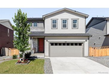 Charming two-story home with a well-maintained lawn, red front door, and a two car garage at 6117 Easton Cir, Frederick, CO 80504