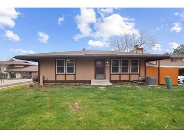 Charming home with a well-maintained lawn and a cozy front porch under a cloudy blue sky at 3746 S Fairplay Way, Aurora, CO 80014