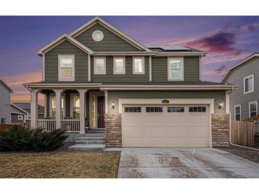 Two-story home featuring an attached two-car garage, covered porch, and stylish stone accents at 16317 Saint Paul St, Thornton, CO 80602