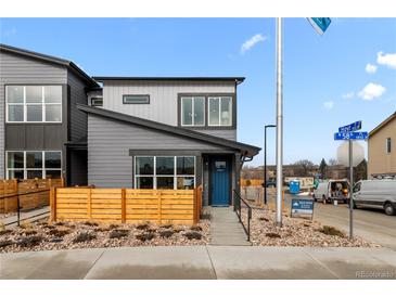 Modern two-story home boasting a blue door, wood fencing, and professional landscaping at 9487 W 58Th Ln # C, Arvada, CO 80002