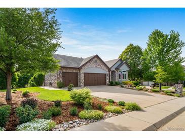 Beautiful home with a three-car garage, gorgeous landscaping, mature trees and a perfectly manicured lawn at 4532 Christensen Cir, Littleton, CO 80123