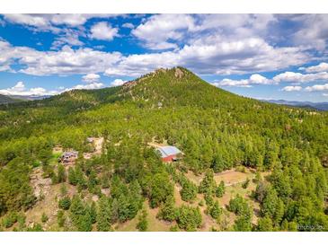 Stunning aerial view of a mountain property with a barn, trees, and a picturesque landscape at 8838 Hillview Rd, Morrison, CO 80465