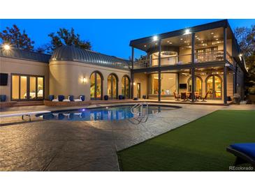 An in-ground pool sits on a stamped concrete patio with plenty of space for entertaining in this luxurious home at 9 Sedgwick Dr, Englewood, CO 80113