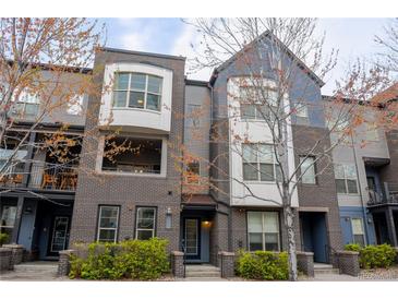 Attractive townhouse exterior featuring gray brick, multiple windows, and small front garden at 451 S Reed St, Lakewood, CO 80226