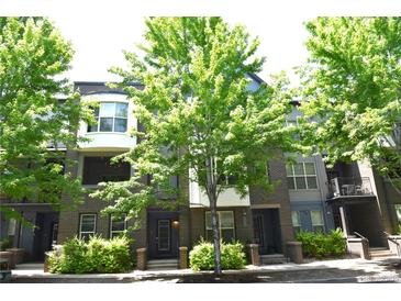 Inviting townhome exterior with brick accents, lush greenery, and mature shade trees at 451 S Reed St, Lakewood, CO 80226