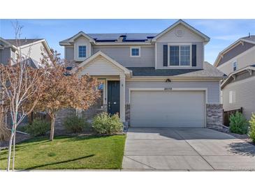 Inviting two-story home with a well-maintained lawn and a two-car garage with grey sidings at 18079 E 108Th Pl, Commerce City, CO 80022