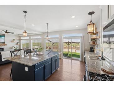 Bright kitchen features stainless steel appliances, granite countertops, and an island with pendant lighting at 18079 E 108Th Pl, Commerce City, CO 80022