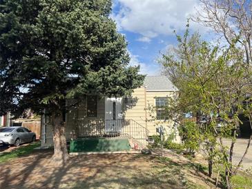 Quaint home with small porch, landscaping and stairs leading to the front door at 1120 Dayton St, Aurora, CO 80010