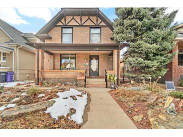 Charming brick home featuring a covered front porch, landscaped yard, and a classic architectural design at 377 S Grant St, Denver, CO 80209