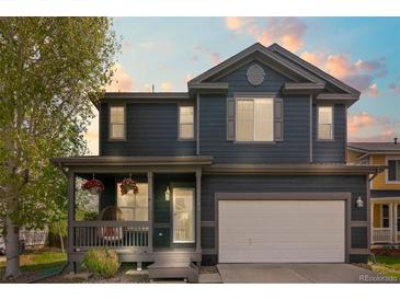 Charming two-story home featuring a cozy front porch and well-maintained lawn at 5249 Mt Arapaho Cir, Frederick, CO 80504