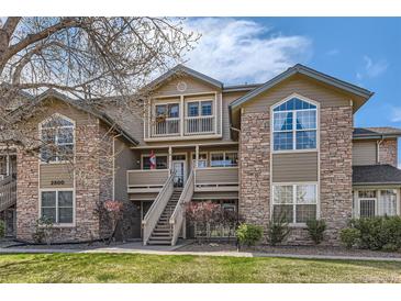 Inviting exterior of a multi-story home featuring stone accents, a landscaped yard, and a charming entryway at 2800 W Centennial Dr # I, Littleton, CO 80123