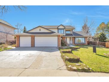 Charming two-story home featuring a brick facade, a three-car garage and a well-manicured front yard at 8055 S Zephyr Way, Littleton, CO 80128
