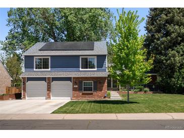 Lovely home featuring solar panels and a driveway leading to the two-car garage, surrounded by lush greenery at 3767 E Phillips Cir, Centennial, CO 80122