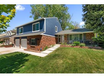 Charming two-story home featuring brick accents, attached two car garage, and a lush green front yard at 3767 E Phillips Cir, Centennial, CO 80122