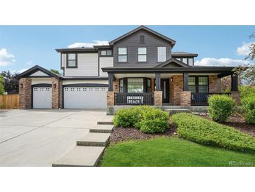 Charming two-story home with a well-manicured lawn and inviting covered front porch at 21434 E Greenwood Pl, Aurora, CO 80013