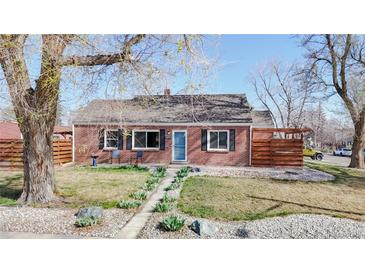 Charming single-story brick home with a well-manicured front yard, walkway, and privacy fence at 7785 E 13Th Ave, Denver, CO 80220