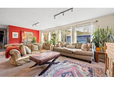 Inviting living room featuring a large sectional sofa, stylish rug, and lots of natural light through the windows at 2041 Virginia St, Idaho Springs, CO 80452